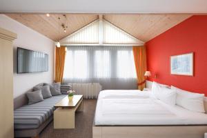 una camera d'albergo con due letti e un divano di Hotel Kellhof - Bed & Breakfast a Gaienhofen