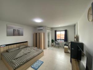 a bedroom with a bed and a living room at 84 Bar & Guest House in Ban Huai Luk (1)