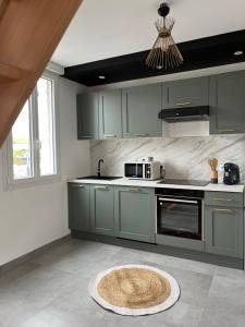 a kitchen with gray cabinets and a rug on the floor at Eau gîte in Ponts-et-Marais
