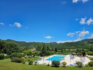 Un resort con piscina y montañas al fondo. en Agriturismo Ca Serrantonio - Ferri Villetta Mozart, en Urbania