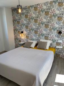 a bedroom with a large white bed with a wall at Eau gîte in Ponts-et-Marais
