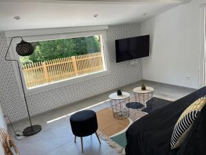 a living room with a large window and a couch at Eau gîte in Ponts-et-Marais