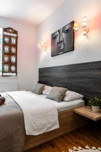 1 dormitorio con 1 cama grande y una foto en la pared en Gusto Apartment, en Kaunas
