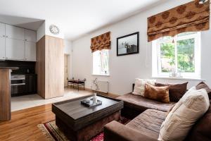 Una sala de estar con un sofá y una mesa de café. en Gusto Apartment, en Kaunas