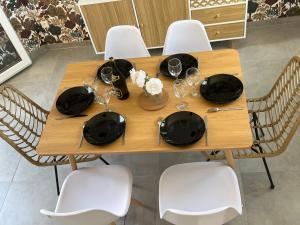 a wooden table with chairs and plates and wine glasses at Eau gîte in Ponts-et-Marais +3 photos