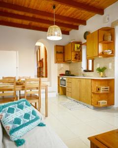 a kitchen and dining room with wooden cabinets and a table at Guest house Dimitra in Sitia