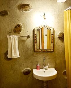 a bathroom with a sink and a mirror and towels at Guest house Dimitra in Sitia