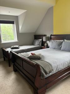LadysbridgeにあるCanaima Houseのベッド2台と窓のある寝室