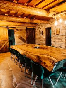 un grande tavolo in legno in una stanza con sedie di Cabană Urșilor Gosen a Vama