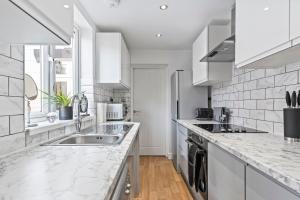 ニューカッスル・アンダー・ライムにある4 Bedroom, 2 Bath in NewCastle Town Centreのキッチン(大理石のカウンタートップ、白いキャビネット付)