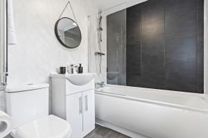 ニューカッスル・アンダー・ライムにある4 Bedroom, 2 Bath in NewCastle Town Centreの白いバスルーム(トイレ、バスタブ、シンク付)