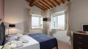 a bedroom with a bed and two windows at Villa Panorama 14, Emma Villas in Chianni +28 photos