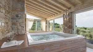 a large bath tub in a room with a window at Villa Panorama 14, Emma Villas in Chianni