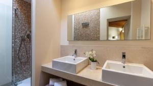 a bathroom with two sinks and a mirror at Villa Panorama 14, Emma Villas in Chianni