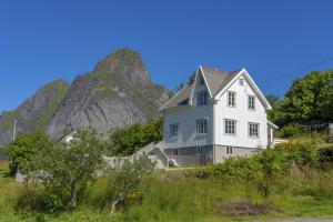 a white house with a mountain in the background at #Reinehuset - Amazing view! in Reine