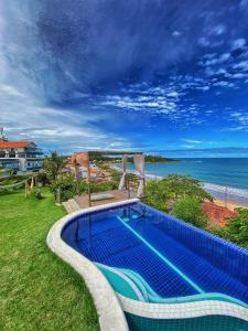 a swimming pool with a view of the ocean at Villa Jardim Mar in Anchieta