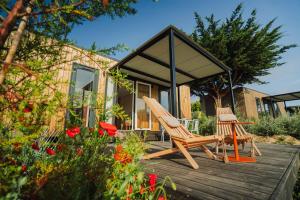 two chairs sitting on a deck in front of a house at Sauvage in Quiberon