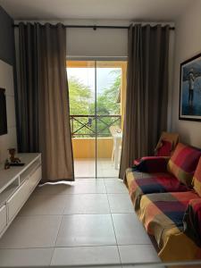 ein Schlafzimmer mit einem Bett und einer Glasschiebetür in der Unterkunft Flat - Condomínio Brisa da Serra - Gravatá in Gravatá