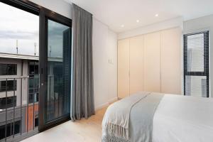 a bedroom with a bed and a large window at Old Cape Quarter 1 Bedroom Units in Cape Town
