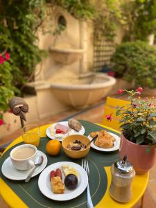 a table with plates of breakfast food on it at Hôtel de la Fontaine in Nice