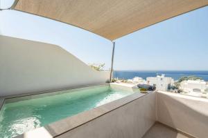 a swimming pool on a balcony with a view of the ocean at Oia Lia in Oia