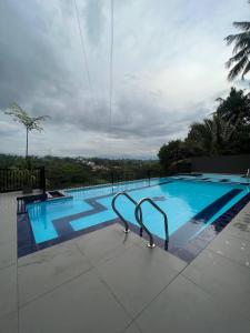 a swimming pool with two chairs next to it at OYO 278 Hotel Rivelka in Kundasale +21 photos