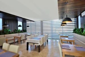 a restaurant with wooden tables and white chairs at Lugga Boutique Hotel & Beach in Ortakent