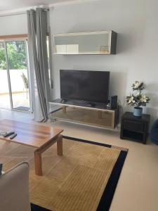 a living room with a large flat screen tv at Cabanas Beach Penthouse in Cabanas de Tavira