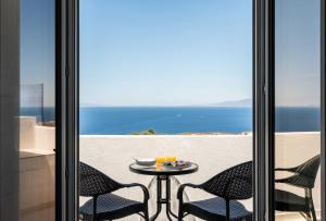 a table and chairs on a balcony with a view of the ocean at Oia Lia in Oia
