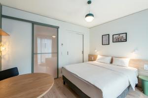 a bedroom with a large bed and a table at Aparthotel Adagio Muenchen City in Munich