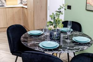 a table with plates and glasses on top of it at Amazonian Luxury Family Home MCR City Centre Etihad Free Parking in Manchester