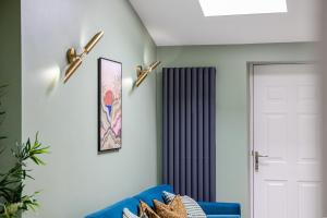 a living room with a blue couch and a door at Amazonian Luxury Family Home MCR City Centre Etihad Free Parking in Manchester