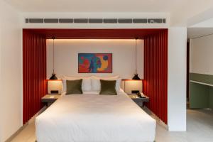 a bedroom with a large white bed with two lamps at Spektrum Hotel - Bengaluru Airport in Bengaluru