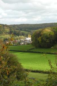 un campo de césped verde con una ciudad al fondo en Romantik Parkhotel het Gulpdal, en Slenaken