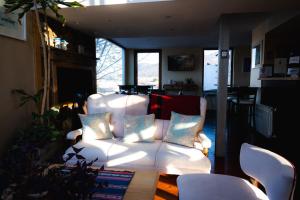 a living room with a white couch and chairs at Hosteria Foike in Ushuaia