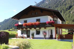 ein Haus mit Blumen im Vorgarten in der Unterkunft Apartment Berger in Sankt Veit in Defereggen