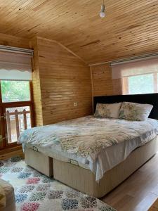 BüyükçakırにあるKapuzbaşı Baştürk Tesisiの木製の壁に大きなベッドが備わるベッドルーム1室