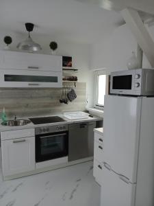 eine weiße Küche mit Herd und Kühlschrank in der Unterkunft Chillkröte in Bad Sobernheim