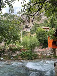 BüyükçakırにあるKapuzbaşı Baştürk Tesisiの家屋を背景に流れる川の眺め +2枚の写真