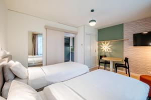 a hotel room with two beds and a table at Aparthotel Adagio Muenchen City in Munich