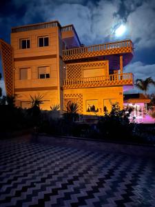 a building at night with the moon behind it at Gite ECOPARADIS in Madagh