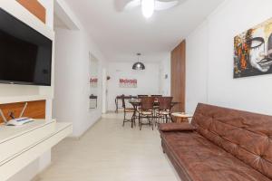 a living room with a couch and a dining room at Excelente Apartamento a 2 minutos da Praia de Bombas in Bombas