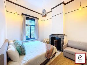 a bedroom with a bed and a fireplace at Le Cœur D'Anvers - Architectural Townhouse in Antwerp