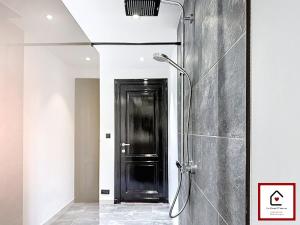 a shower in a bathroom with a black door at Le Cœur D'Anvers - Architectural Townhouse in Antwerp