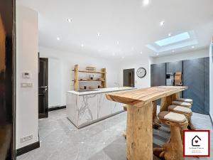 a kitchen with a wooden table and stools at Le Cœur D'Anvers - Architectural Townhouse in Antwerp