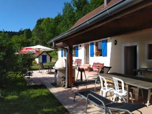 Un patio con sillas, una mesa y una sombrilla. en Vogesenparadies, en Kirchberg