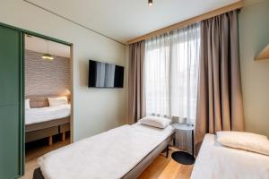 a hotel room with two beds and a window at Aparthotel Adagio Muenchen City in Munich