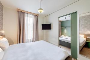 a hotel room with a bed and a mirror at Aparthotel Adagio Muenchen City in Munich