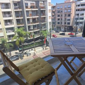 een tafel en stoel op een balkon met uitzicht op de stad bij Studio ALMASSIRA in Casablanca