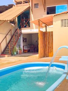 a swimming pool in front of a house at Pousada e Hostel Maria Bonita in Paripueira